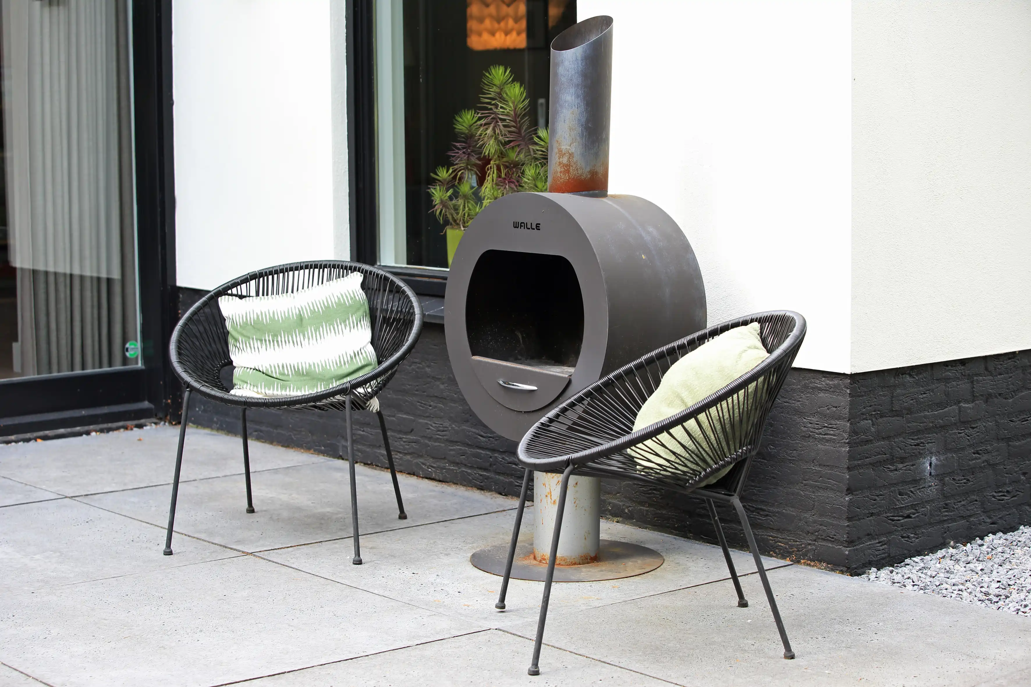 Moderne buitenruimte met designstoelen en buitenhaard