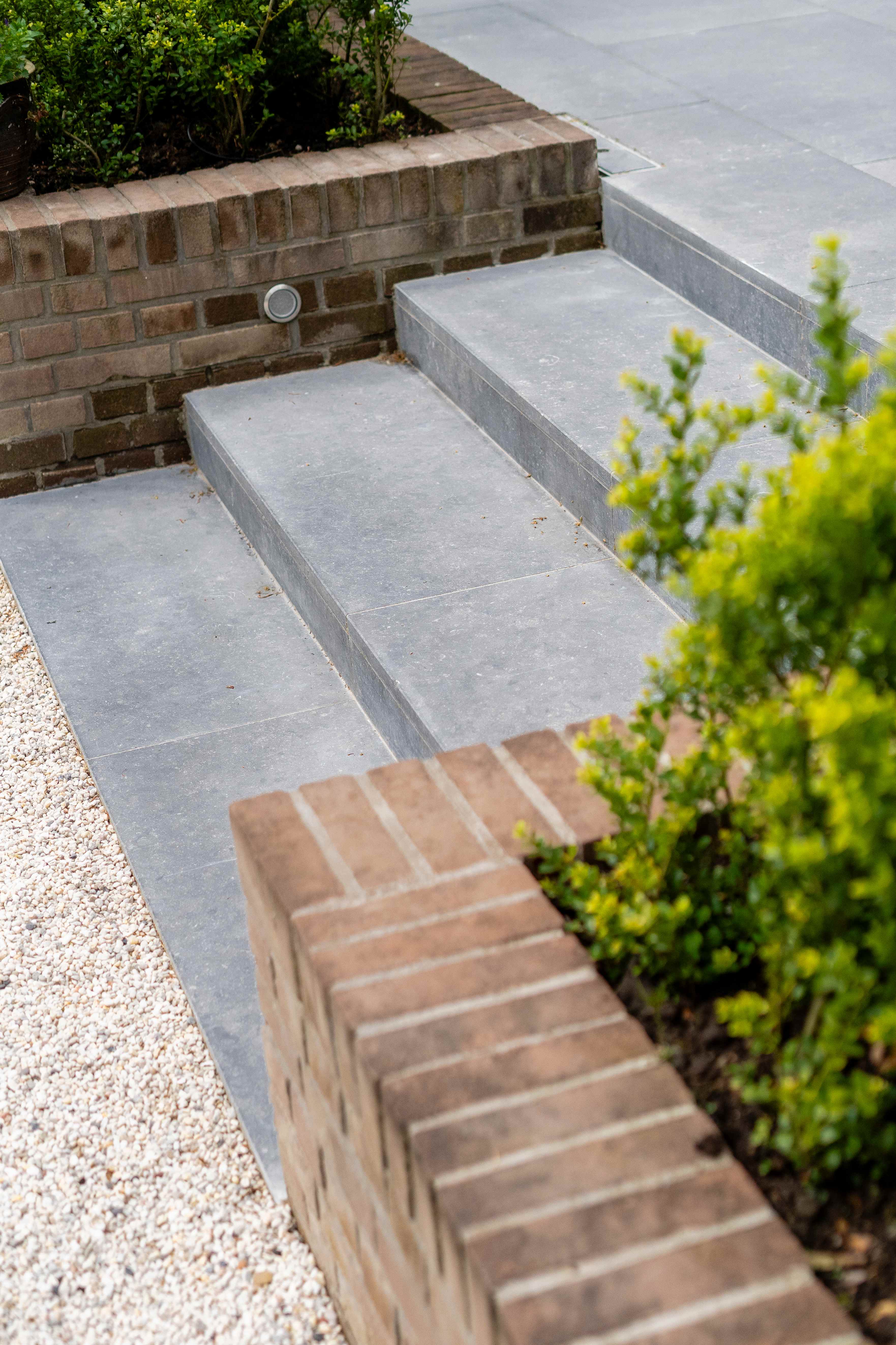 Detailopname van stenen traptreden met bakstenen keermuren en geïntegreerde verlichting