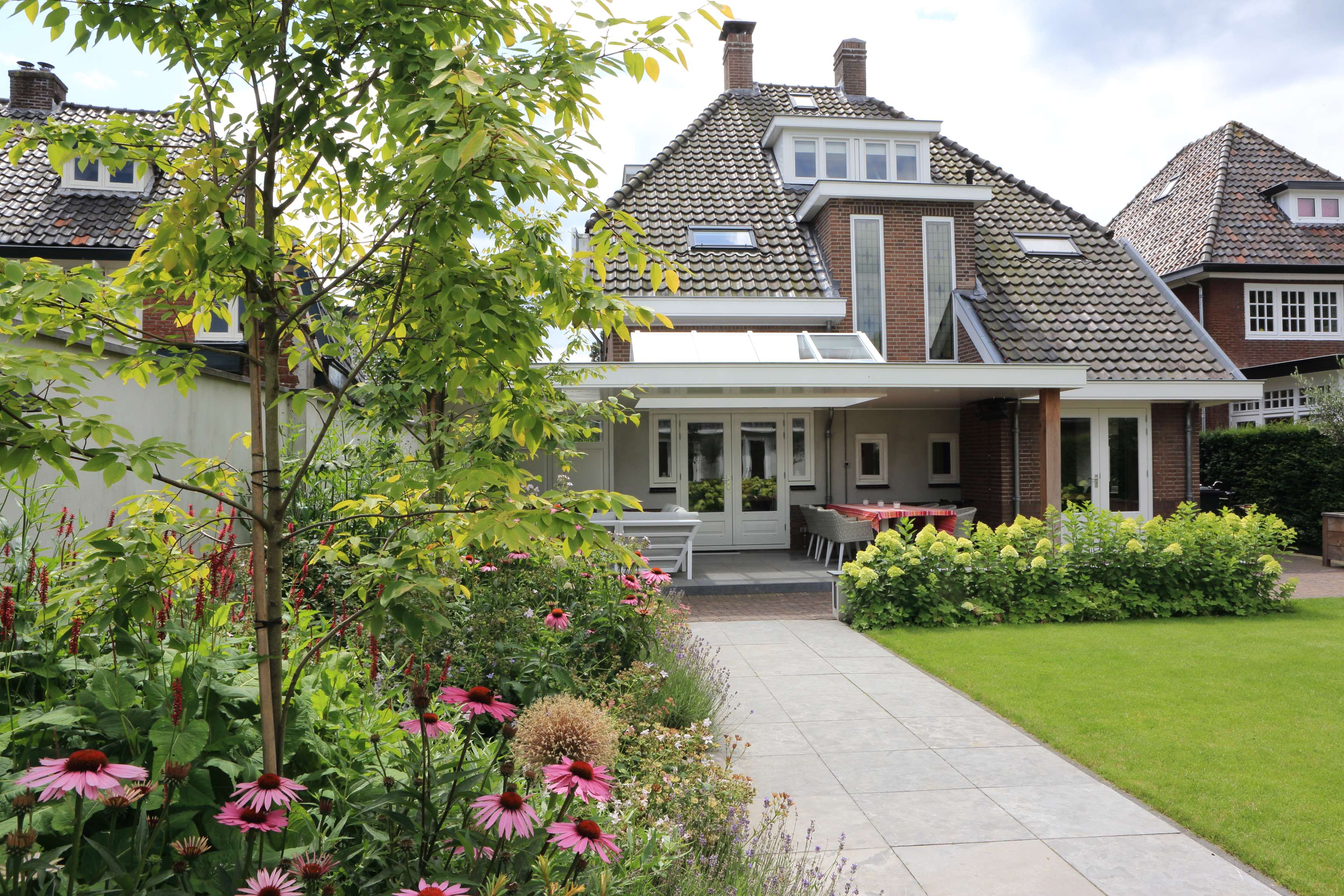 Familietuin met centraal gazon en royale veranda