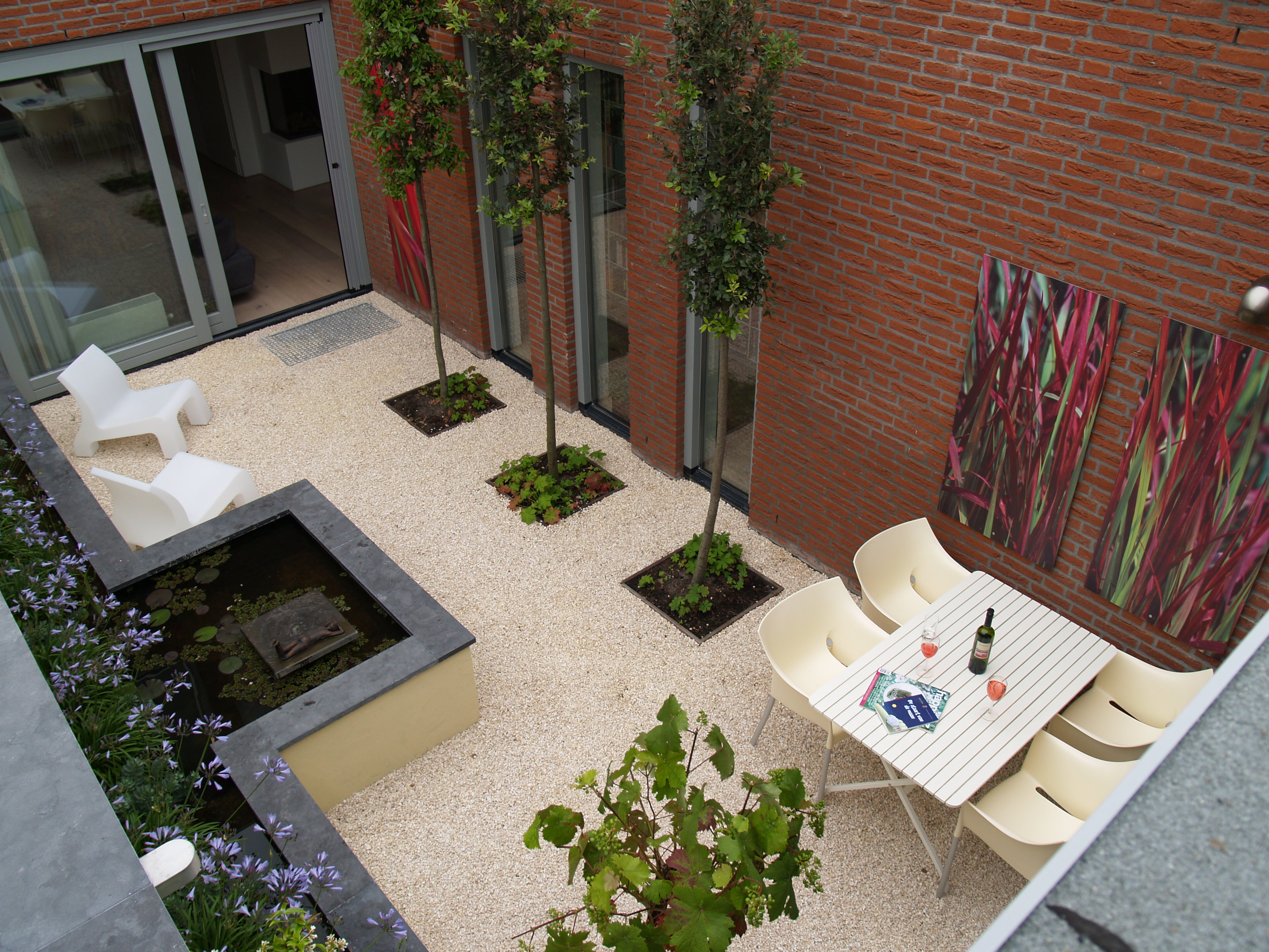 Luchtfoto eettafel met wijn, wintergroene bomen en kleurrijke kunstpanelen