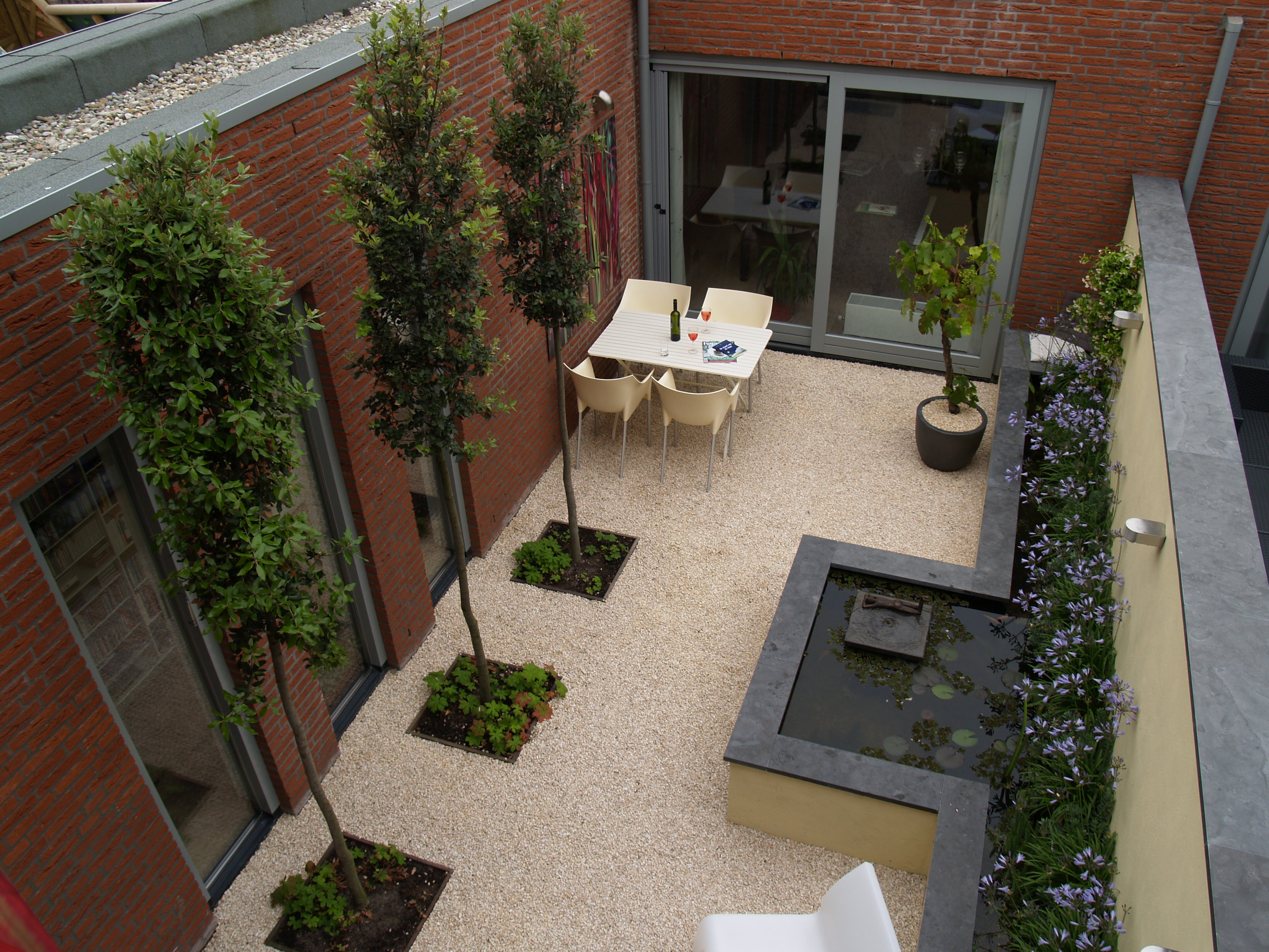 Luchtfoto van complete patiotuin met eettafel, vijver en druivenrank
