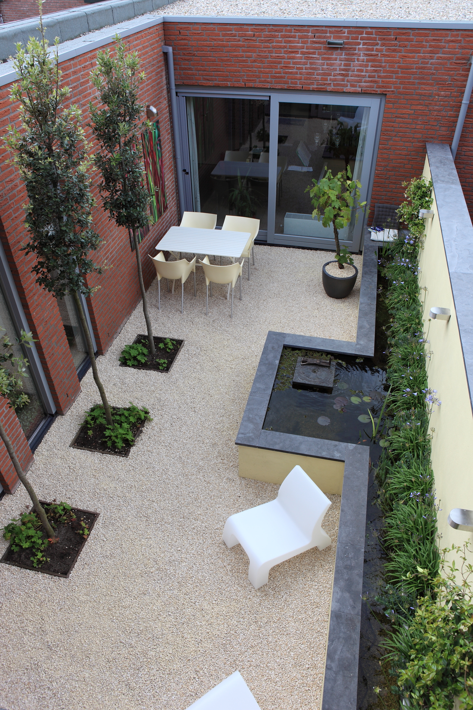 Luchtfoto complete indeling met vijver, sculptuur en loungestoel